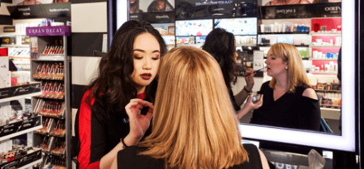 Woman applying makeup to customer